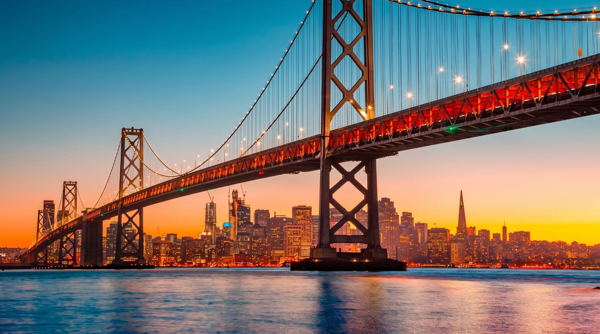 The San Francisco skyline at dusk under the Bay Bridge